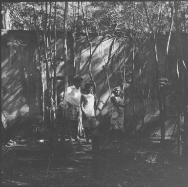 Three people near the prison wall on the Isle of Pines, New Caledonia, 1967 / Michael Terry