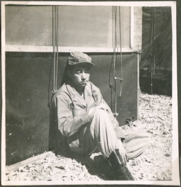 Soldier seated next to a tent