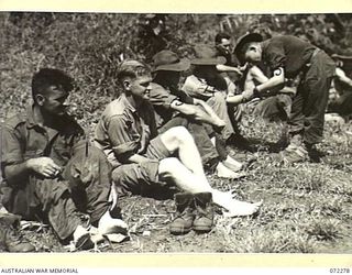 YAULA, NEW GUINEA. 1944-04-09. MEMBERS OF THE 57/60TH INFANTRY BATTALION RECEIVING TREATMENT FOR BLISTERED FEET ALONGSIDE THE ROAD WITHIN SIX MILES OF BOGADJIM. IDENTIFIED PERSONNEL ARE:- VX143569 ..