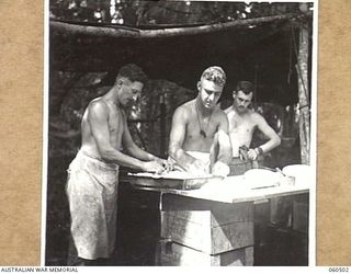 FINSCHHAFEN AREA, NEW GUINEA. 1943-11-13. COOKS OF THE HEADQUARTERS, 9TH AUSTRALIAN DVISION MAKING A PIE OF THE RATION M AND V, (MEET AND VEGETABLES) IN AN EFFORT TO MAKE IT MORE PALATABLE