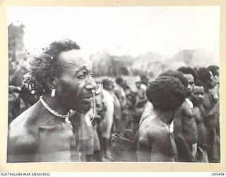 KIARIVU, NEW GUINEA, 1945-08-17. REFUGEE NATIVES LINED UP ON THE AIRSTRIP FOR COUNTING AND INSPECTION BY CAPTAIN R.R. COLE, THE ASSISTANT DISTRICT OFFICER, AUSTRALIAN NEW GUINEA ADMINISTRATIVE ..