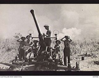 NADZAB AREA, NEW GUINEA. 1943-09-20. PERSONNEL OF THE 11TH BATTERY, 2/4TH AUSTRALIAN LIGHT ANTI-AIRCRAFT REGIMENT MANNING THEIR 40 MM BOFORS GUN, AWAITING THE SECOND WAVE OF JAPANESE RAIDERS. DENSE ..