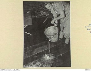 LAE, NEW GUINEA, 1945-05-07. GUNNER M. WHEELER, CLEANING UP SLEEPING QUARTERS AT THE AUSTRALIAN WOMEN'S ARMY SERVICE BARRACKS IN BUTIBUM ROAD. SHE IS A MEMBER OF A GROUP OF 342 AUSTRALIAN WOMEN'S ..