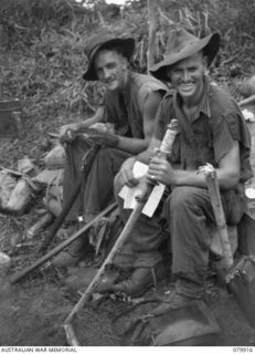 DAGUA, NEW GUINEA. 1945-03-25. NX21119 PRIVATE A. WEBB (1), AND NX69093 PRIVATE J.R. ROWSELL (2), MEMBERS OF THE 2/2ND INFANTRY BATTALION, COMPARE JAPANESE SWORDS CAPTURED AT THE AIRSTRIP