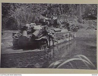 BOUGAINVILLE, 1945-05-16. A MATILDA TANK OF B SQUADRON 2/4 ARMOURED REGIMENT, SUPPORTED BY INFANTRY CROSSING THE HONGORAI RIVER, IN THE 24 INFANTRY BATTALION ADVANCE SOUTH ALONG THE BUIN ROAD. ..