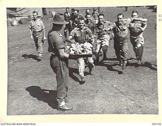 WEWAK AREA, NEW GUINEA, 1945-06-13. A RUSH FOR A HAND OUT OF CREAM PUFFS FOLLOWS A CALL BY CAPT C.C.O. PIPKORN, SUPERVISOR OF ARMY CATERING, ATTACHED TO 6 DIVISION (1). COOKS FROM VARIOUS 6 ..