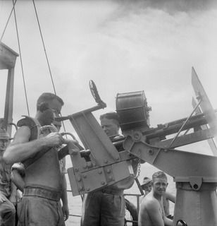 NEW BRITAIN. 1945-05-01. BRIGADIER BAXTER-COX, MILITARY HISTORY SECTION (1), AND CAPTAIN TANNER, MASTER OF THE AK82, 16 WATERCRAFT COMPANY, ROYAL AUSTRALIAN ENGINEERS (2), EXAMINE A HISPAMO 20MM ..