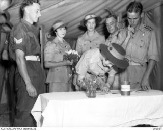 TOROKINA, BOUGAINVILLE, 1945-08-15. PTE. E.M. TOWNSEND (2), SIGNING THE REGISTER AFTER HER MARRIAGE TO CPL J.H. RICKARD (1), IN THE CHAPEL, 2/1 GENERAL HOSPITAL. THE SERVICE WAS CONDUCTED BY ..