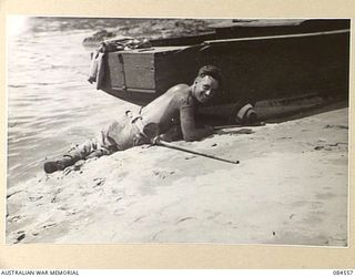 LABU, NEW GUINEA. 1944-12-22. CORPORAL DAVIS, 43 LANDING CRAFT COMPANY, THE COMMANDING OFFICER'S COXSWAIN, EFFECTING MINOR REPAIRS. THIS LAUNCH WAS BUILD BY LIEUTENANT BENNETT DURING HIS SPARE TIME