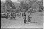 Bride price ritual: decorated men from the groom's group dance into the bride's village