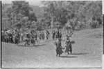 Bride price ritual: decorated men from the groom's group dance into the bride's village