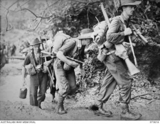 GAMAN, NEW GUINEA. 1944-05-27. FORWARD TROOPS OF THE 35TH INFANTRY BATTALION NEGOTIATING CORAL ROCKS DURING THEIR ADVANCE UP THE COAST TOWARDS WEWAK. IDENTIFIED PERSONNEL ARE:- NX135925 CORPORAL ..