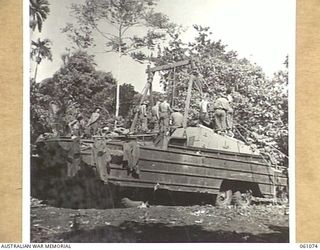 FINSCHHAFEN AREA, NEW GUINEA. 1943-11-04. A FIELD BAKERY BEING ESTABLISHED ON THE NORTHERN BANK OF THE BUMI RIVER. THIS PHOTOGRAPH SHOWS MEMBERS OF THE 4TH AUSTRALIAN FIELD BAKERY PLACING SHEER ..