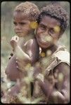 Western Highlands: smiling woman with face tattoo, holding young child