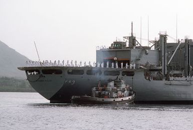 The large harbor tugs NOGALES (YTB 777) assists the combat stores ship USS NIAGARA FALLS (AFS 3) upon her arrival at Naval Station Guam. The crew is manning the rail