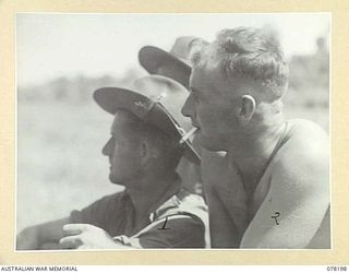 YAKAMUL, NEW GUINEA. 1945-01-09. QX166 PRIVATE C. CHAMBERS (1) AND NX101630 PRIVATE J.O. MURRAY (2) MEMBERS OF THE 2/2ND INFANTRY BATTALION AND "JOCK FORCE" LISTENING WITH INTEREST TO CAPTAIN A J ..