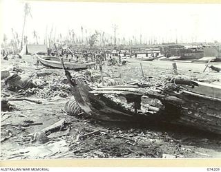 HANSA BAY, NEW GUINEA. 1944-06-22. SHELL BLASTED JAPANESE BOATS AND STORES LITTERING THE BEACH NEAR THE CAMP SITE OF THE 4TH INFANTRY BATTALION
