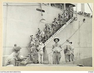 JACQUINOT BAY, NEW BRITAIN. 1944-11-04. TROOPS OF NO. 7 PLATOON A COMPANY, 14/32ND AUSTRALIAN INFANTRY BATTALION BOARDING THE BARGES OF THE 594TH ENGINEER BOAT AND SHORE COMPANY, UNITED STATES ARMY ..