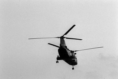 A CH-46 Sea Knight helicopter takes off from the amphibious assault ship USS GUAM (LPH 9) during Operation URGENT FURY