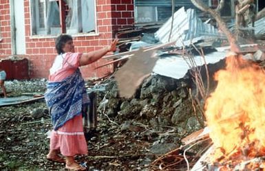 Island resident, Ms. Sinaitaaga Lefao, burns debris from Cyclone Val in the village of Fagaitua on the South Pacific island of American Samoa