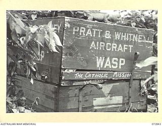 ALEXISHAFEN, NEW GUINEA. 1944-04-30. A PRATT AND WHITNEY WASP AIRCRAFT ENGINE ADDRESSED TO THE ROMAN CATHOLIC MISSION WHICH HAS BEEN LEFT INTACT BY THE JAPANESE. A NATIVE ARTIFACT IS ON THE TOP OF ..