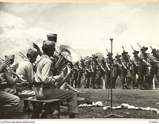 LAE, NEW GUINEA, 944-03-08. THE MARCH PAST OF THE 29TH INFANTRY BRIGADE TO THE ACCOMPANIMENT OF A UNITED STATES ARMY BAND. THE BRIGADE HAD BEEN IN NEW GUINEA FOR FOURTEEN MONTHS, AND HAS SEEN ..