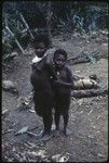 Young girl wearing shell valuable, stands with another child