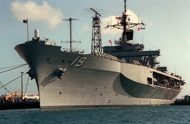 A port bow view of the amphibious command ship USS BLUE RIDGE (LCC-19) moored at a pier