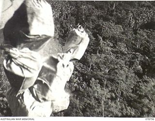 PEARL RIDGE AREA, BOUGAINVILLE ISLAND. 1945-01-30. PERSONNEL OF THE SOLOMON'S DETACHMENT, 12TH AIR MAINTENANCE PLATOON (TS), 4TH BASE SUB AREA, DROPPING SUPPLIES FROM ONE OF THEIR AIRCRAFT TO ..