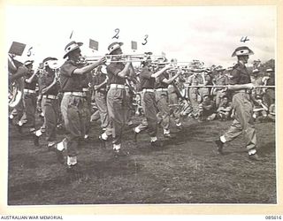 HERBERTON RACECOURSE, WONDECLA, ATHERTON TABLELAND, QLD. 1945-01-19. THE 2/13 INFANTRY BATTALION BAND PARTICIPATING IN THE BAND CONTEST DURING THE 9 DIVISION GYMKHANA. IDENTIFIED PERSONNEL ARE:- ..