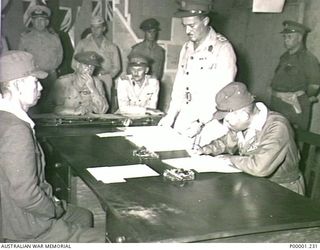 THE SOLOMON ISLANDS, 1945-09-08. VICE ADMIRAL TOMOSHIGE SAMEJIMA, COMMANDER EIGHTH FLEET, SIGNING THE INSTRUMENT OF SURRENDER AT II AUSTRALIAN CORPS HEADQUARTERS AT TOROKINA, BOUGAINVILLE ISLAND, ..