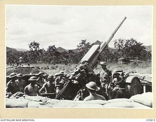 PORT MORESBY, PAPUA. 1942-07. THESE GUNNERS FOUGHT GERMAN AND ITALIAN PLANES IN THE MIDDLE EAST. HERE THEY ARE SEEN MANNING AN ANTI-AIRCRAFT GUN DURING A JAPANESE RAID IN NEW GUINEA. THEY WORK ..