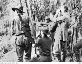 GOODVIEW, NEW GUINEA, 1943-08-10. THE GENERAL OFFICER COMMANDING, 3RD AUSTRALIAN DIVISION, OBSERVING JAPANESE POSITIONS IN THE KOMIATUM AREA FROM A "D" COMPANY FORWARD OBSERVATION POST. LEFT TO ..