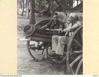 PORT MORESBY, PAPUA, 1944-02. DRIVER NORRIS J. COSSINS, NEW GUINEA FORCE PUBLIC RELATIONS FIELD UNIT (1), AND PRIVATE FIRST CLASS CLAY H. ALLEN OF OZERK, MISSOURI TALK THINGS OVER WHILE RECLINING ..