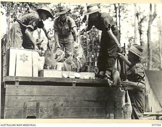 TOROKINA, BOUGAINVILLE ISLAND. 1944-12-24. PERSONNEL OF THE 9TH INFANTRY BATTALION LOADING TURKEYS, HAMS, CHRISTMAS HAMPERS AND PLUM PUDDINGS ON TO A TRUCK AT THE BATTALION HEADQUARTERS FOR ..