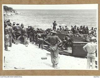 KANOMI BEACH, NEW GUINEA. 1944-01-05. TROOPS OF THE 2/23RD AUSTRALIAN INFANTRY BATTALION, 26TH AUSTRALIAN INFANTRY BRIGADE, 9TH AUSTRALIAN DIVISION GOING ABOARD BARGES FOR THEIR TRIP UP THE COAST ..