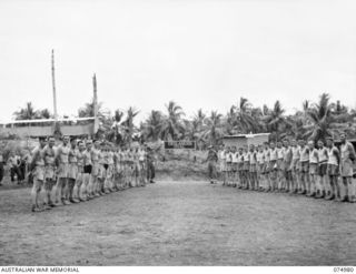 NAGADA, NEW GUINEA. 1944-07-26. AUSTRALIAN RULES FOOTBALL TEAMS OF THE 29/46TH INFANTRY BATTALION AND THE 37/52ND INFANTRY BATTALION LINED UP BEFORE THEIR MATCH ON THE DESLANDES SPORTS OVAL. THIS ..