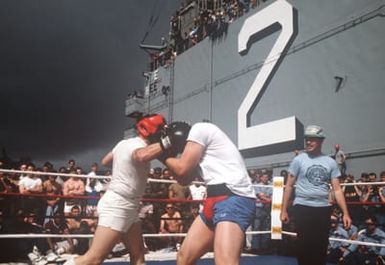 Crew members gather on the flight deck to watch a boxing match aboard the amphibious assault ship USS SAIPAN (LHA 2)