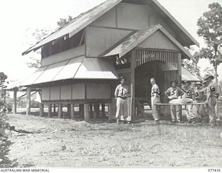 LAE BASE AREA, NEW GUINEA. 1944-12-01. VX26857 LIEUTENANT R.R. SMITH, COMMANDING NO. 2 PLATOON, 22ND WORKS COMPANY (1) SUPERVISING THE MOVING OF ANOTHER BED INTO THE UNIT HOSPITAL. AS THIS IS A B ..