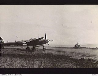 LAE, NEW GUINEA. 1943-10-04. A LOCKHEED LIGHTNING OF THE UNITED STATES ARMY AIR FORCE ON THE AIRSTRIP. IN THE BACKGROUND IS A PARTLY SUNKEN JAPANESE SHIP