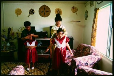 Two girls getting dressed for ear-piercing ceremony, Lakepa, Niue