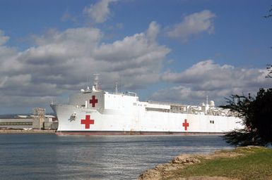 A port bow view of the US Navy (USN) Military Sealift Command (MSC) Hospital Ship, USNS MERCY (T-AH 19) conducting re-supply operations while moored to the pier at Naval Base Pearl Harbor, Hawaii (HI), for a brief port visit prior to deploying to Southeast Asia to provide assistance to victims of the devastating Tsunami that hit the region in support of Operation UNIFIED ASSISTANCE