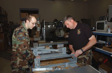 US Air Force (USAF) SENIOR AIRMAN (SRA) David Gerdes, left and MASTER Sergeant (MSGT) Steve Evon, both with the 155th Air Refueling Wing (ARW) Lincoln, Nebraska (NE), build racks that will hold Uninteruptable Power Sources (UPS) for network servers for the 154th Communications Flight, Hickam Air Force Base (AFB), Hawaii (HI)