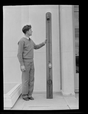 Unidentified man with a light panel relic from the American Airways Sikorsky flying boat 'Samoan Clipper', at Musick Point Air Radio Station, Howick, Auckland