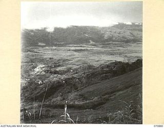 WAU - BULLDOG ROAD, NEW GUINEA, 1944-02-24. THE WAU VALLEY FROM THE FIVE-AND-A-HALF MILE POINT ALONG THE REINHOLD HIGHWAY VIEWED AT ABOUT 7000 FEET ABOVE SEA LEVEL, AND JUST BELOW CLOUD LEVEL