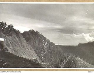 SHAGGY RIDGE, NEW GUINEA. 1943-12-27. UNITED STATES FIGHTER AIRCRAFT STRAFING JAPANESE POSITIONS ON THE "PIMPLE" DURING THE ASSAULT ON THE RIDGE BY TROOPS OF THE 2/16TH AUSTRALIAN INFANTRY ..