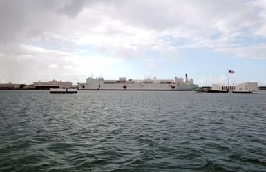 The U.S. Navy Military Sealift Command Mercy Class Hospital Ship USNS MERCY (T-AH 19) sails past the USS ARIZONA Memorial (front) as it prepares to moor at Naval Station Pearl Harbor, Hawaii, on Sept. 20, 2006, for a brief port visit enroute to its homeport at Naval Base San Diego, Calif. The MERCY, a converted San Clemente Class Super Tanker, is at the end of a five-month humanitarian and civic assistance deployment to Southern and Southeast Asia. (U.S. Navy photo by Mass Communication SPECIALIST 1ST Class James E. Foehl) (Released)