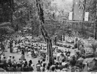 RAMALE VALLEY, NEW BRITAIN. 1945-10-02. ARMY PERSONNEL LISTENING TO A STAGE ITEM "ADVANCE AUSTRALIA FAIR" AT THE CONCERT STAGED AS A THANKSGIVING FOR LIBERATION AT RAMALE MISSION. PERSONNEL OF 11 ..