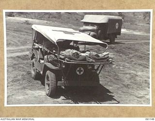 12 MILE, PORT MORESBY AREA, NEW GUINEA. 1943-12-03. DEMONSTRATION OF A NEW JEEP AMBULANCE DESIGNED AND BUILT BY THE TROOPS OF THE 2ND AUSTRALIAN MOTOR AMBULANCE CONVOY