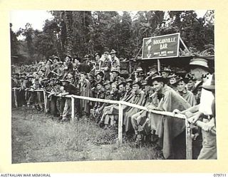 TOROKINA, BOUGAINVILLE, SOLOMON ISLANDS. 1945-03-11. A SECTION OF THE CROWD, WATCHING THE FOOTBALL MATCH BETWEEN THE 24TH INFANTRY BATTALION AND THE 58/59TH INFANTRY BATTALION DURING THE SPORTS ..